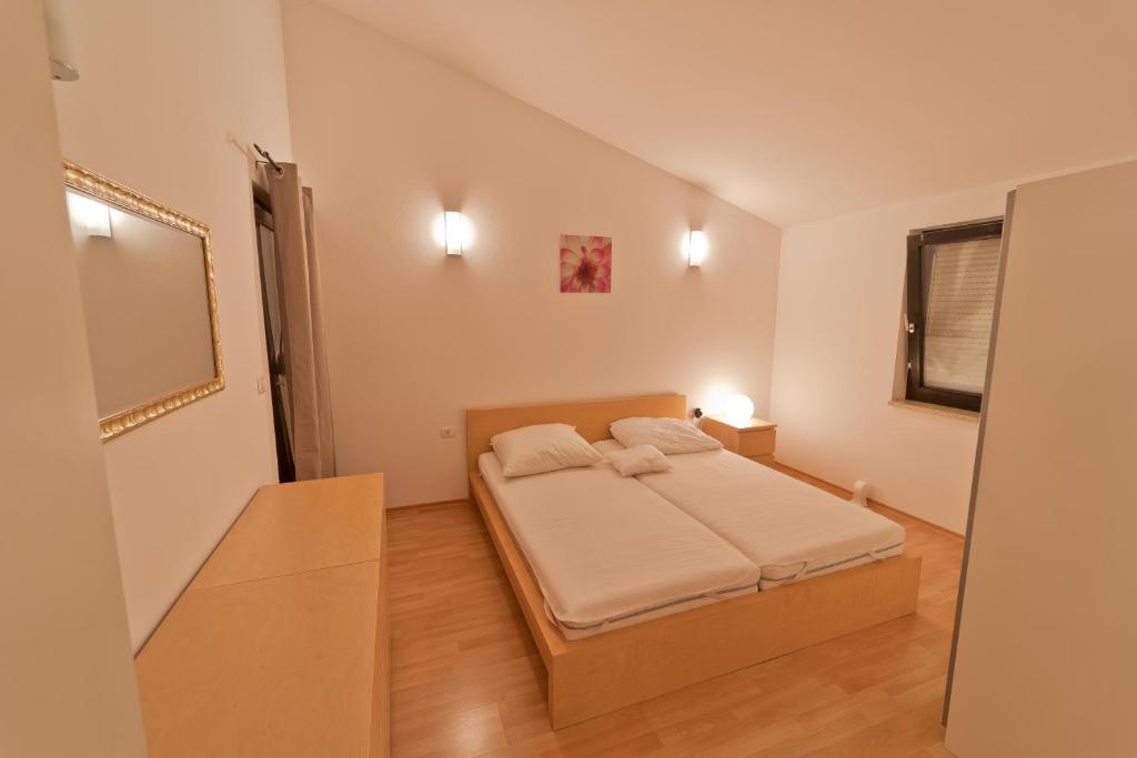 una piccola camera da letto con un letto e uno specchio di Villa Twins Markovic a Pola (Pula)