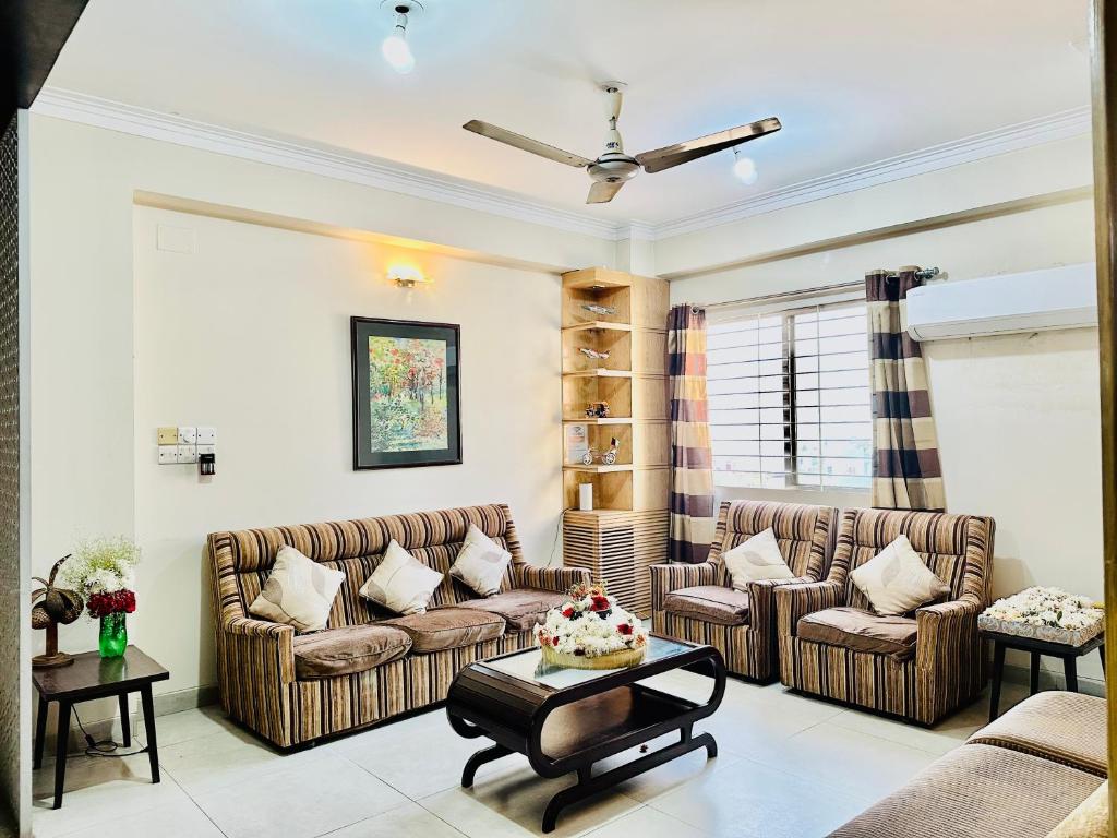 ein Wohnzimmer mit 2 Sofas und einem Tisch in der Unterkunft Impressa on Shah in Dhaka