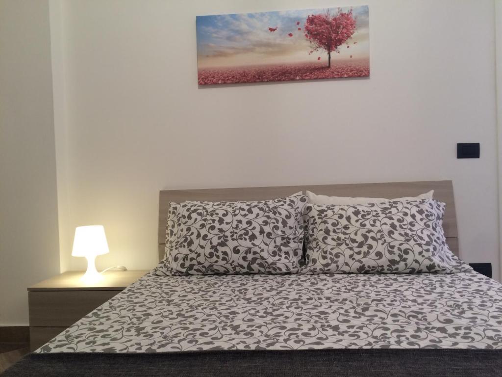 een slaapkamer met een bed en een boom aan de muur bij Centro storico, nuovo con terrazzo in Lido di Ostia