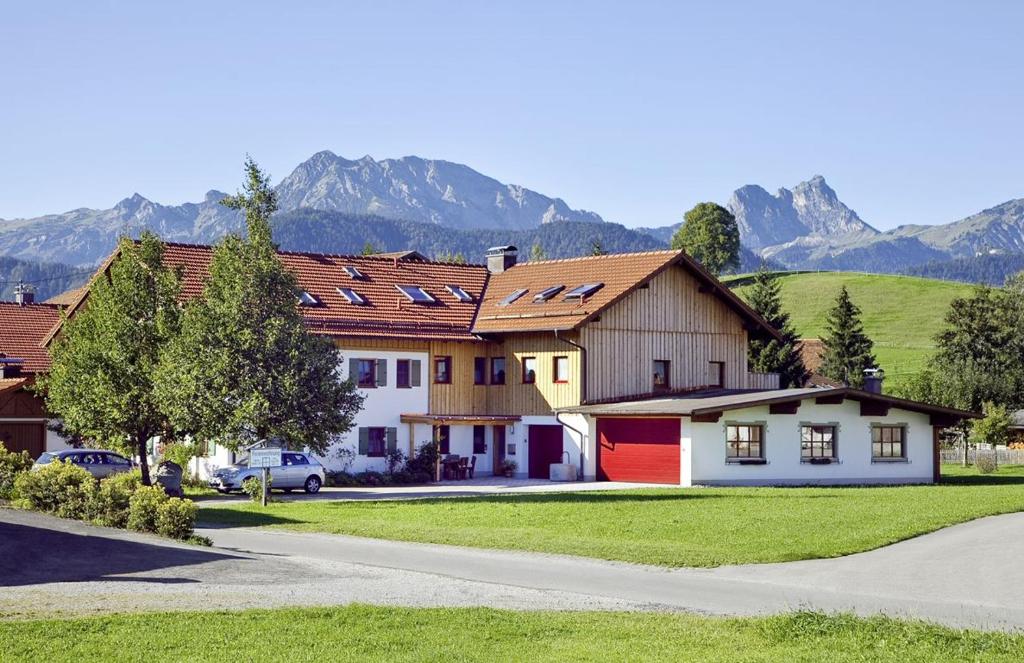 a group of houses with mountains in the background at Best Butler Alp Villa 11 Personen I Blockhütte I Parken I Lagerfeuer I Netflix in Hopferau