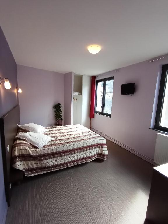 1 dormitorio con cama y ventana en Hôtel du Commerce en Pléaux