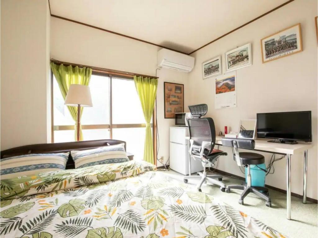 1 dormitorio con cama, escritorio y ordenador en Minpaku Yamamoto - Vacation STAY 13869, en Izumiotsu