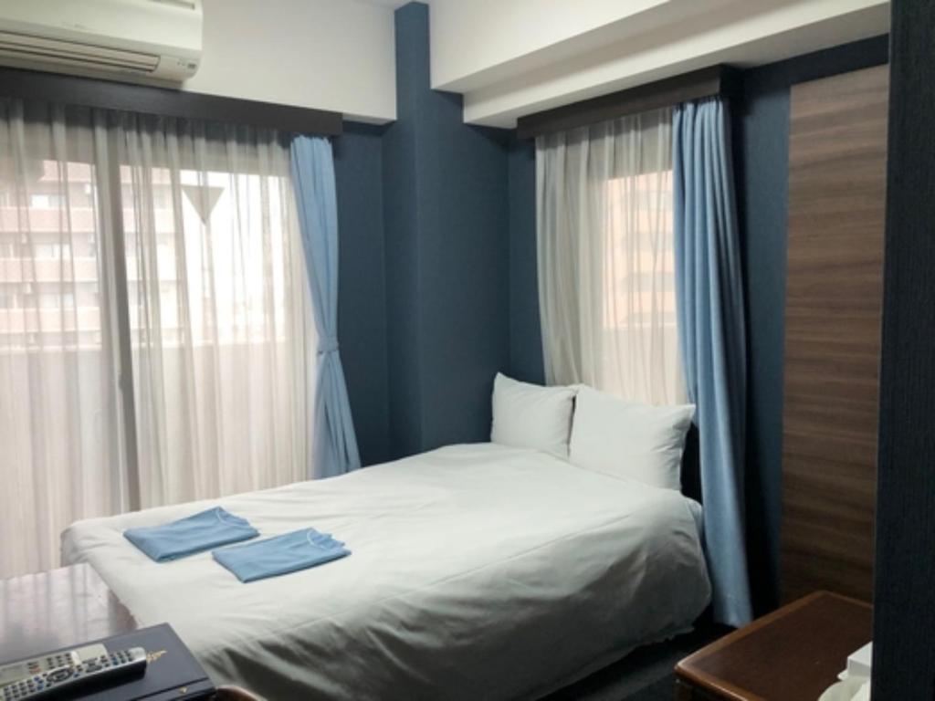 sypialnia z łóżkiem z dwoma niebieskimi ręcznikami w obiekcie Hotel Business Villa Omori - Vacation STAY 08205v w Tokio
