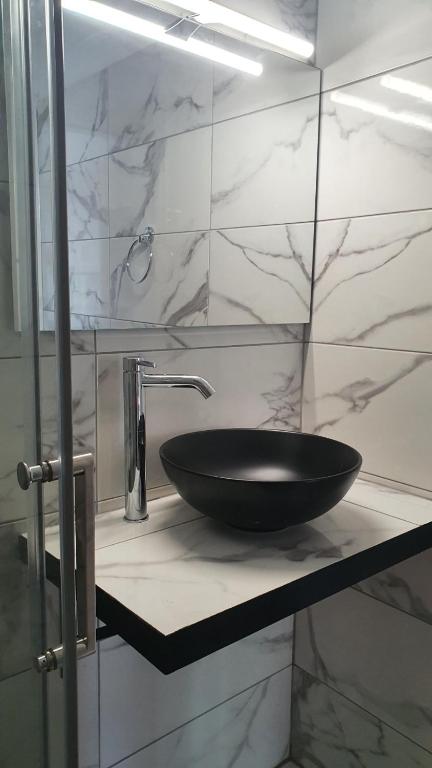 umywalkę w łazience z czarną miską na ladzie w obiekcie Serenita verde Apartment w mieście Poros