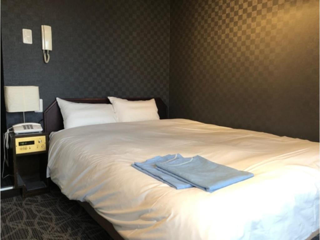 東京にあるHotel Business Villa Omori - Vacation STAY 08209vのベッドルーム1室(青いシャツ付きのベッド1台付)