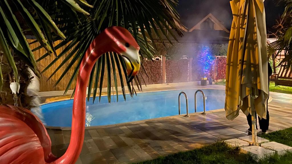 uma estátua de flamingo ao lado de uma piscina à noite em Villa Bade sıcak havuzlu em Sapanca