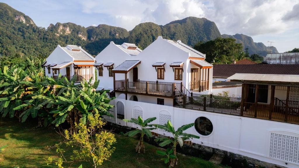 uma fila de casas com montanhas ao fundo em Phang Nga Origin Hotel em Phangnga