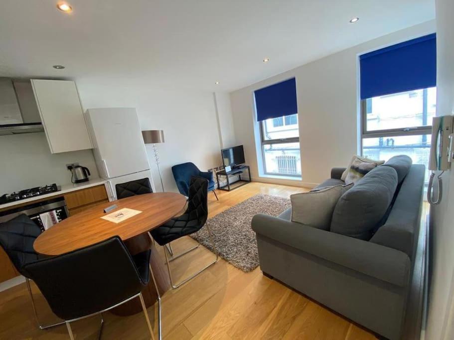 ein Wohnzimmer mit einem Sofa und einem Tisch in der Unterkunft A beautiful and cozy home in the heart of london in London