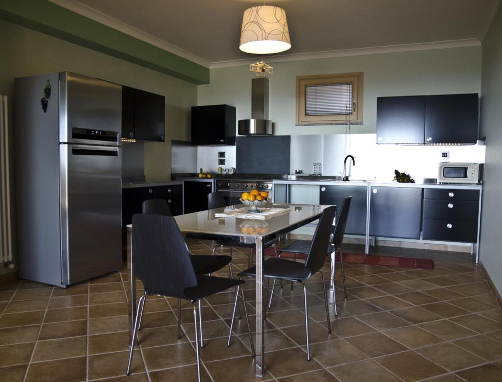 a kitchen with a table and chairs and a refrigerator at Casa Vacanza Cicirello in Giardini Naxos