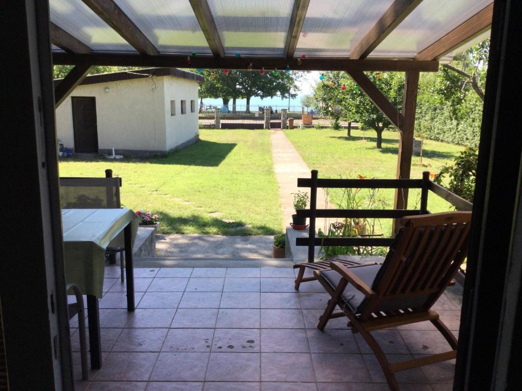 a patio with two chairs and a table and a view of a yard at Füge Vendégház Csopak in Csopak