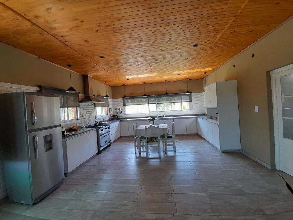 cocina con electrodomésticos blancos y techo de madera en Casa quinta 281 en La Plata