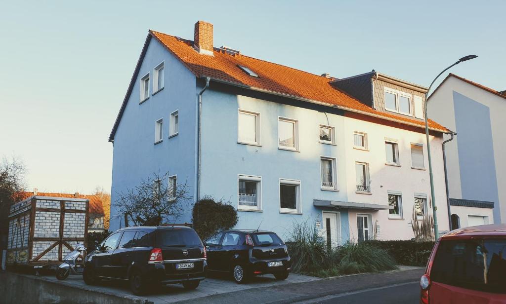 バート・フィルベルにあるFerienwohnung Bad Vilbelの青い家の前に停められた車2台