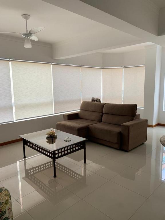 ein Wohnzimmer mit einem Sofa und einem Couchtisch in der Unterkunft Apartamento Capão da Canoa in Capão da Canoa