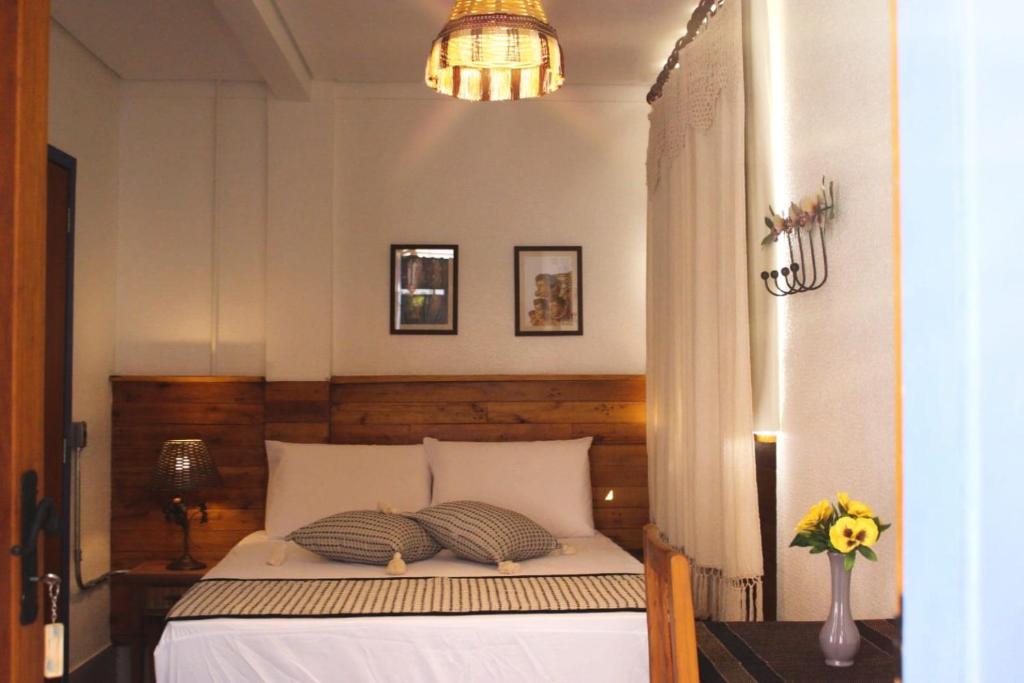 a bedroom with a bed and a chandelier at Pousada Caminhos de Minas Belo Horizonte in Belo Horizonte