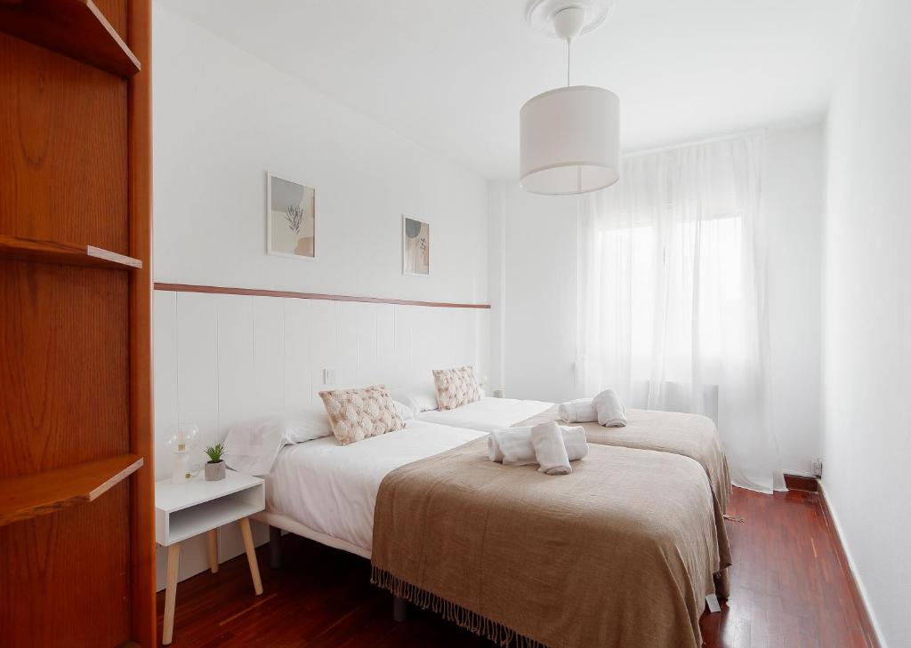 1 dormitorio con 2 camas y toallas. en 165A Apto moderno 2 dormitorios en Gijón