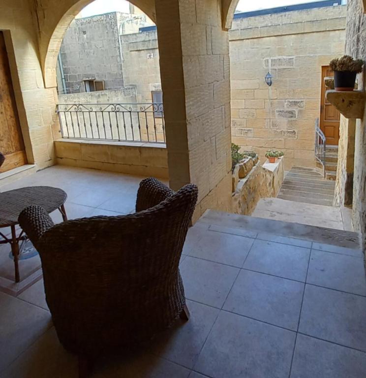 a patio with two chairs and a table and a window at Ta Majsi farmhouse with indoor heated pool in San Lawrenz