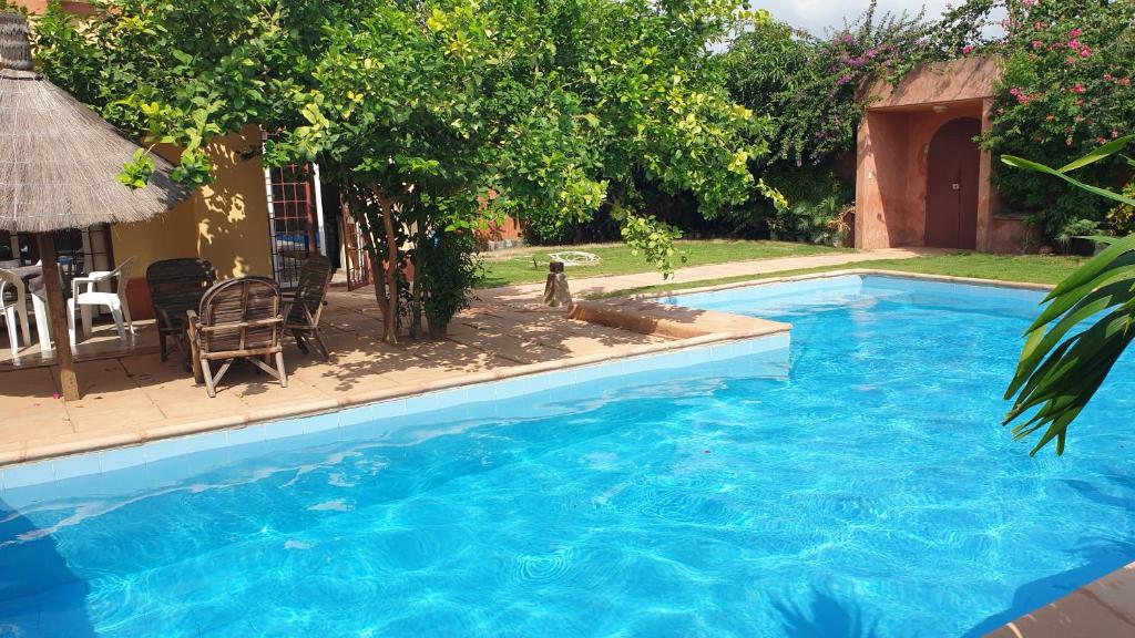 a large blue swimming pool next to a house at Magnifique Villa Riad avec piscine proche plage in Saly Portudal