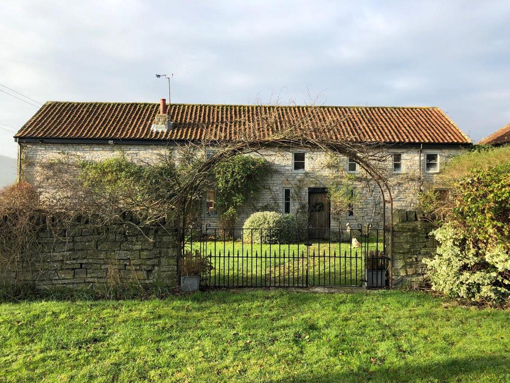 an old stone house with an iron gate at Peaceful stone barn conversion in Somerset in Hurcot