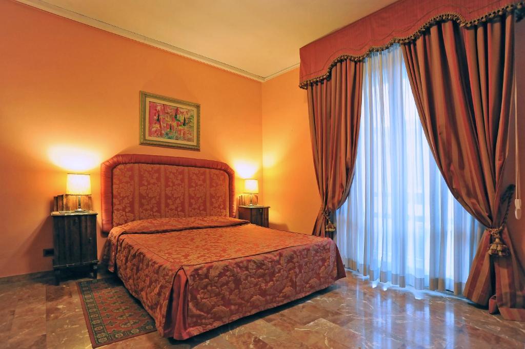 a bedroom with a bed and a large window at Residenza Cantagalli in Florence