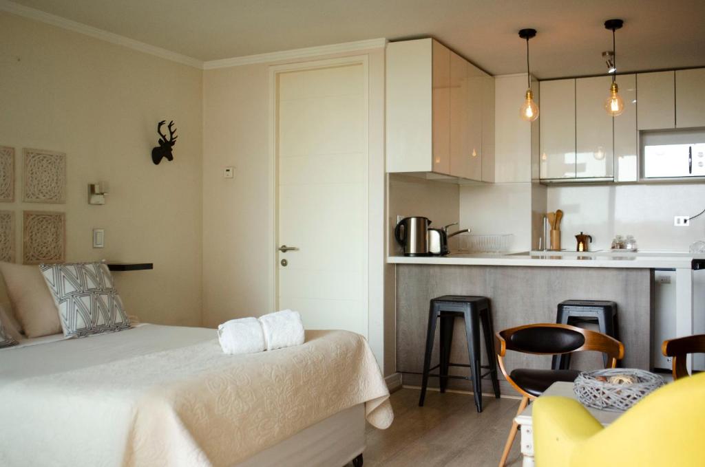 Habitación pequeña con cama y cocina en Loica Suites, en Santiago
