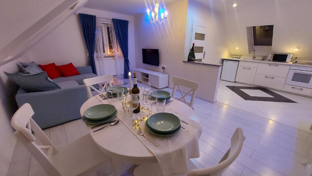 een woonkamer met een eettafel en een keuken bij Apartamenty Malwa in Lądek-Zdrój