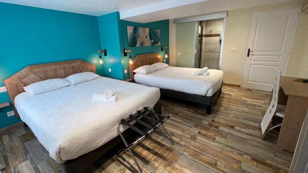 2 letti in una camera con pareti blu di Logis Hôtel Restaurant Bellevue a Saint-Martin-dʼArdèche