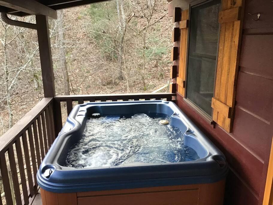 einen Whirlpool auf einer Veranda mit einem Fenster in der Unterkunft Dollywood! Brand new Dancing Bear 3-Bear Tracks in Pigeon Forge