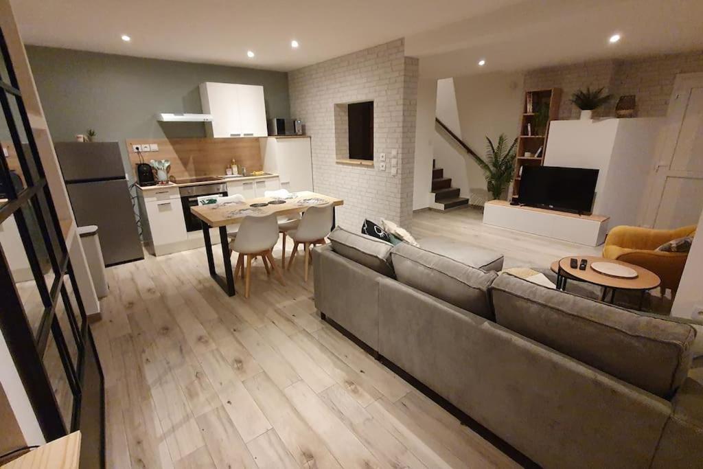 sala de estar con sofá, mesa y cocina en Maison tout confort centre de Nogent sur Seine en Nogent-sur-Seine