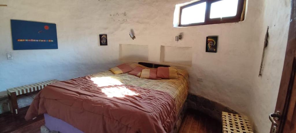 1 dormitorio con 1 cama en una habitación con ventana en Casa Pachamama en Tilcara
