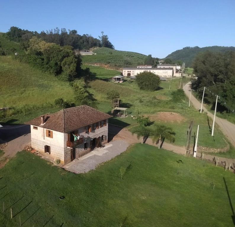 z góry widok na dom na zielonym wzgórzu w obiekcie Casa de Campo Província Minosso w mieście Farroupilha