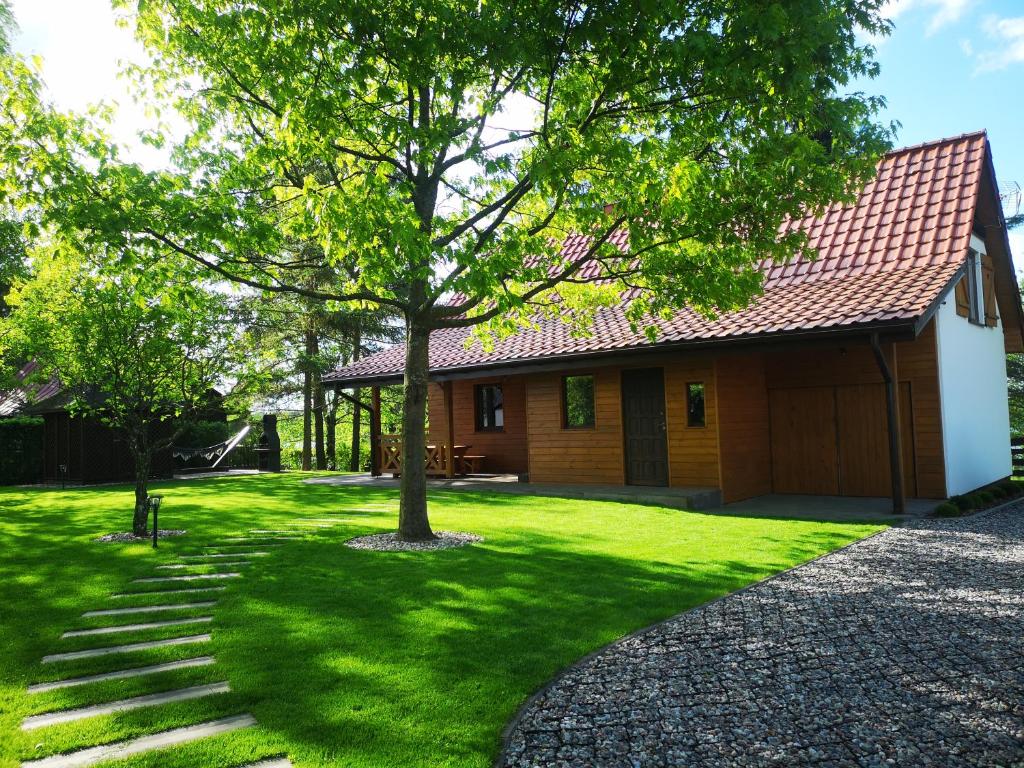 una casa con un árbol en el patio en Bajkowy Domek Nad Samym Jeziorem en Narty