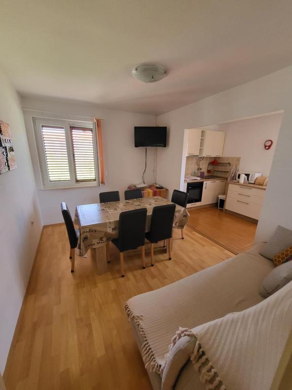 salon ze stołem, krzesłami i kanapą w obiekcie Island Paradise Apartment w mieście Kukljica