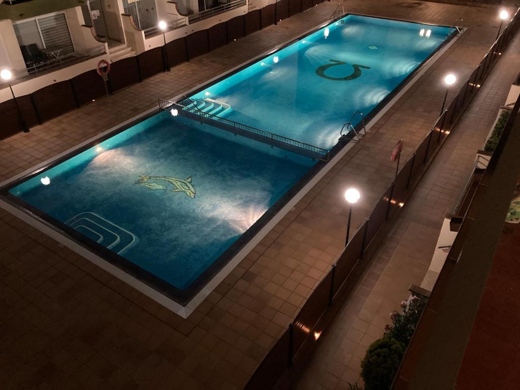 una vista panoramica su una piscina di notte di Apartamento L'Estartit a L'Estartit