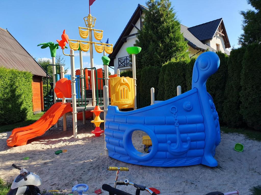 a playground with a blue playset in the sand at Zagroda in Sarbinowo