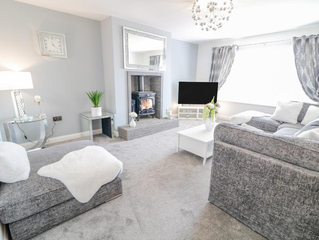 a living room with a couch and a fireplace at SJs Cottage in Coleraine