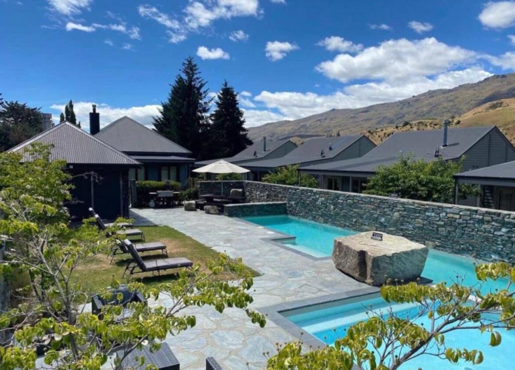 a backyard with a swimming pool and a house at Cardrona Mountain Chalet with Pool and Jacuzzi in Cardrona