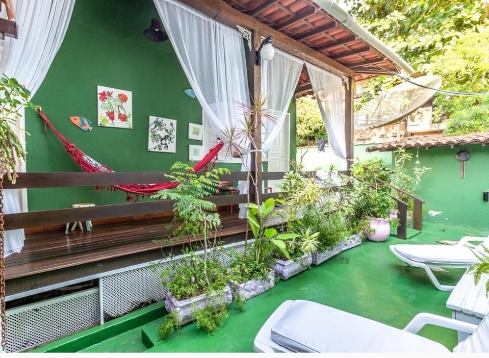 uma varanda com plantas e uma parede verde em Búzios Casa Verde em Búzios