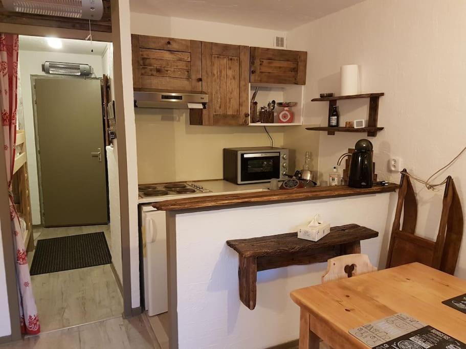 a kitchen with a counter and a refrigerator and a table at Studio agréable in Les Contamines-Montjoie
