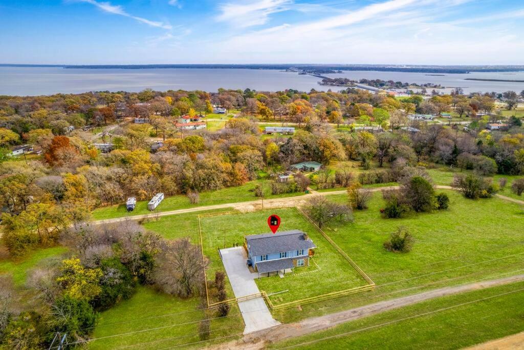 an aerial view of a house on a field with a lake at Acre lakes house in Kemp