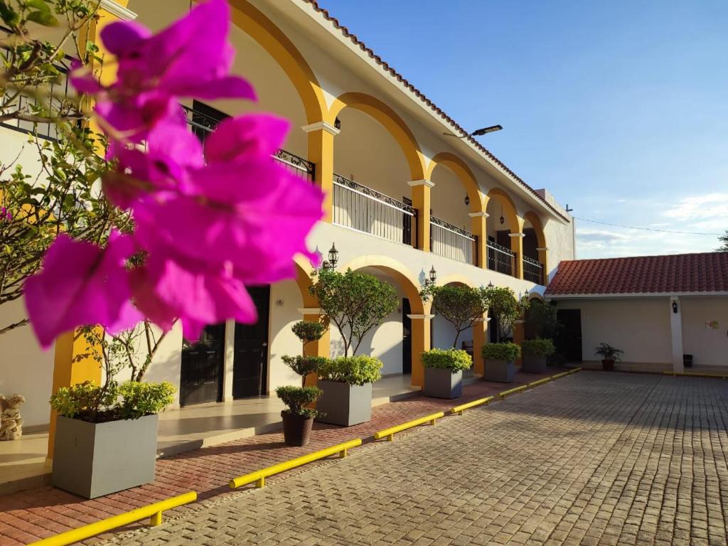 un bâtiment avec des fleurs roses devant lui dans l'établissement Casa Blanca Hotel, à Jalpan de Serra