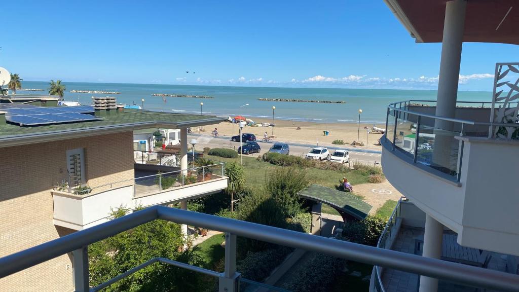 una vista sulla spiaggia dal balcone di un edificio di Appartamento “Le vele” a Porto San Giorgio