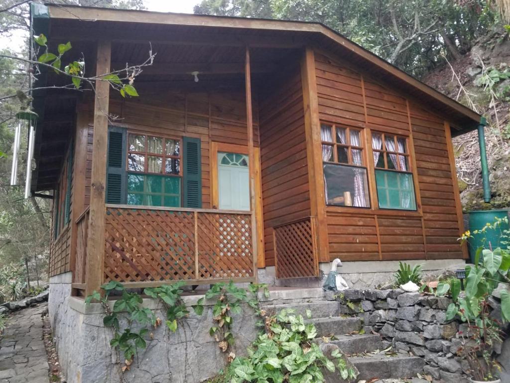 a log cabin with stairs leading to the front door at Chalet in the Woods in Santiago Atitlán