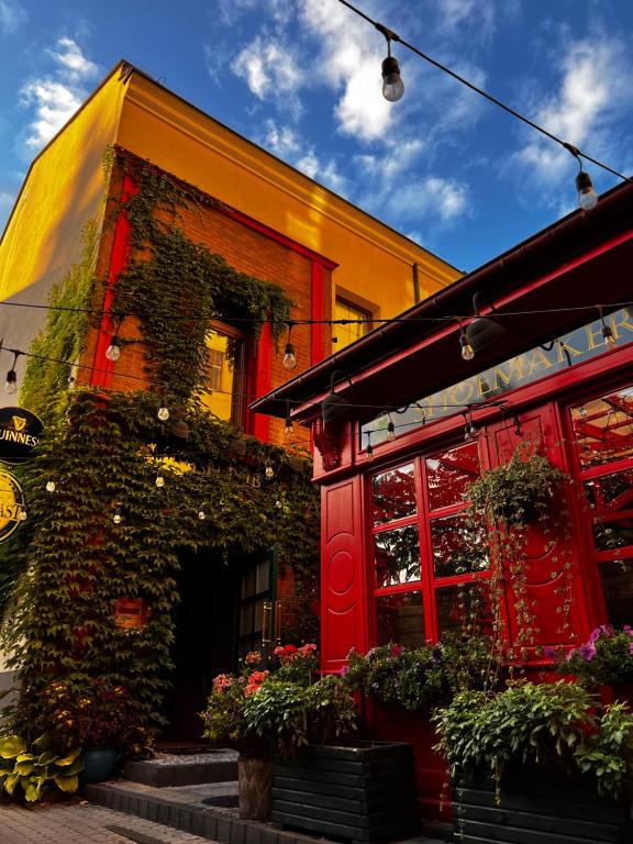 un edificio rojo con plantas a su lado en Shoemaker Irish Pub & Accommodation, en Kielce