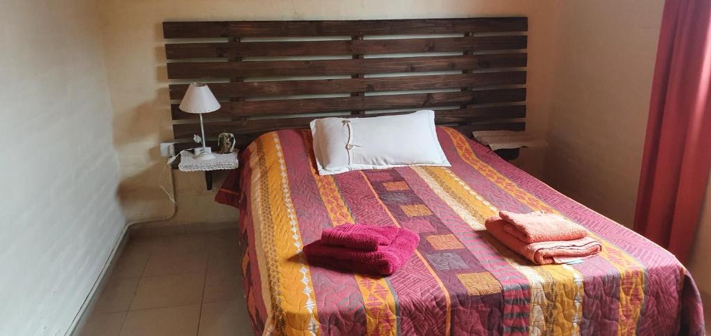 1 dormitorio con 1 cama con 2 toallas en Cabaña Refugio De Caminantes in 