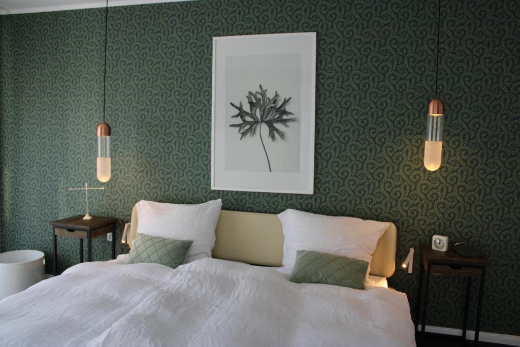 a bedroom with a white bed and two lights at Ferienwohnung GeestZuhause in Heeslingen