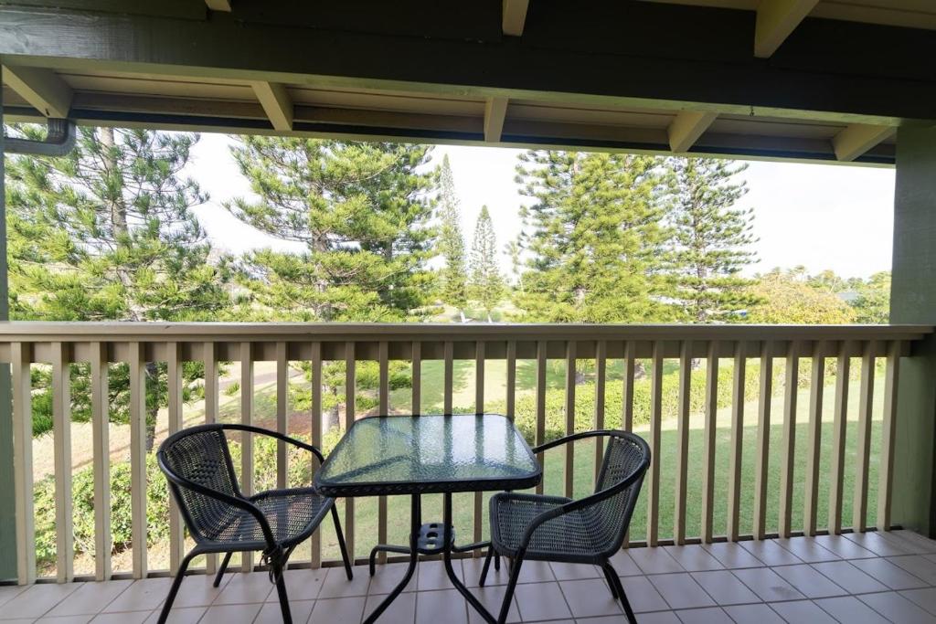 a table and two chairs on a screened in porch at Takanoha Condo in Kahuku