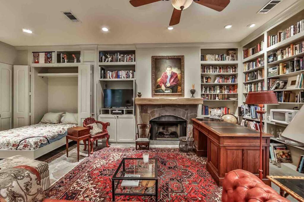 ein Wohnzimmer mit einem Kamin und ein Zimmer mit einem Bett und einem Sofa in der Unterkunft Artist's Library with a Private Swimming Pool in Houston