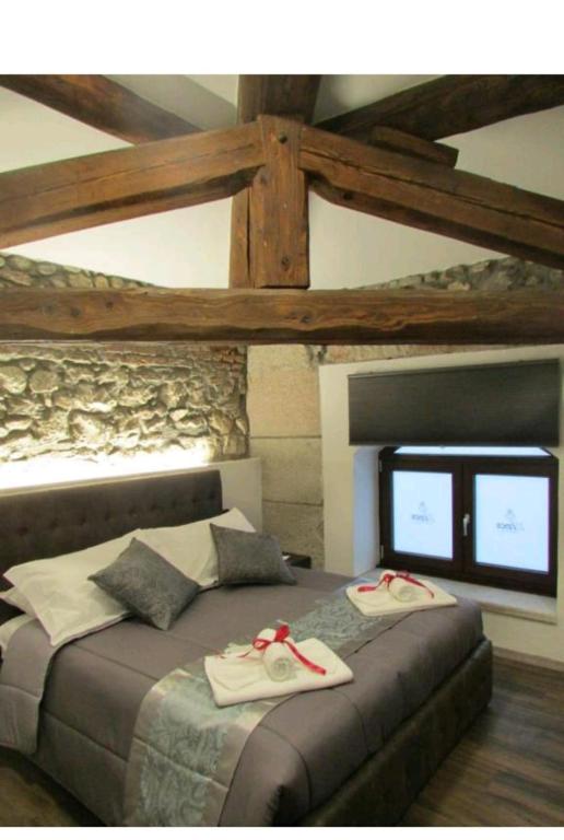a bedroom with a bed with two slippers on it at ATTIKO 53 Boutique Rooms in Verona