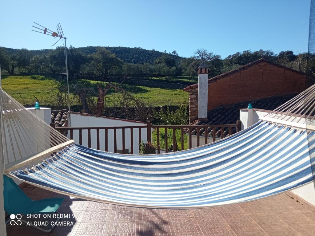 a blue and white hammock in front of a house at El Corchuelo in Corteconcepción