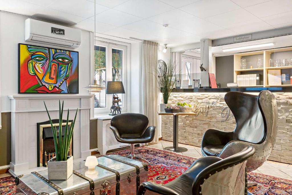 a living room with a fireplace and a painting on the wall at Best Western Hotel Anno 1937 in Kristianstad